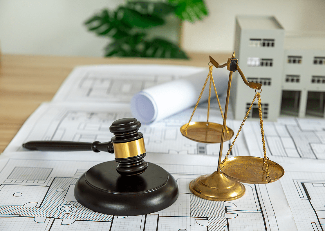 Gavel and scales on architectural blueprints.